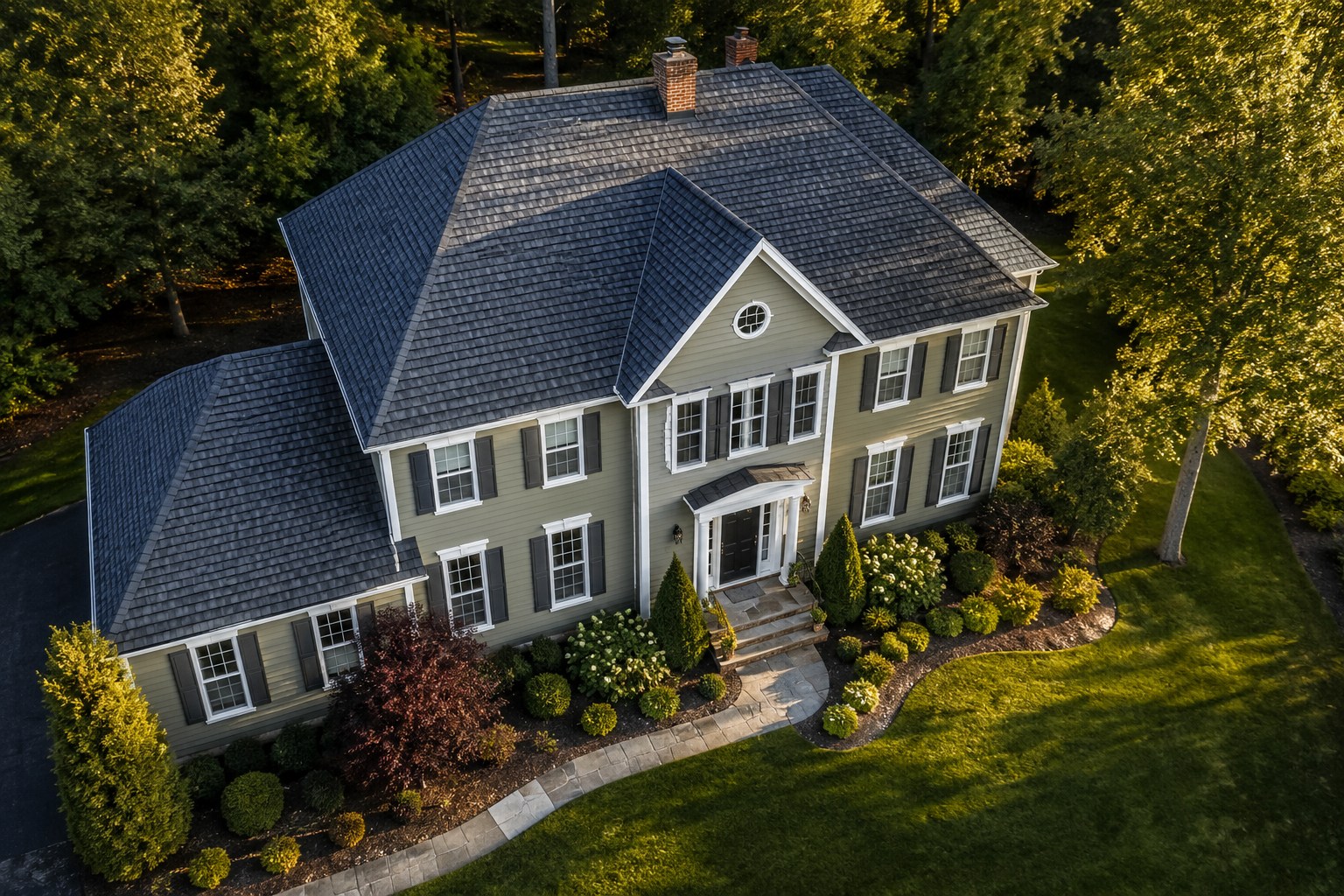 Three-quarter drone view of a colonial home showing facade and full roof plane